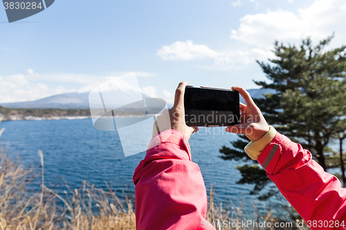 Image of Woman take the photo by cellphone for Mountain Fuji