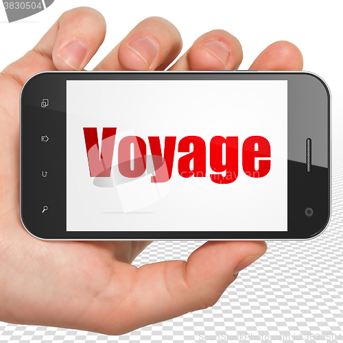 Image of Travel concept: Hand Holding Smartphone with Voyage on display