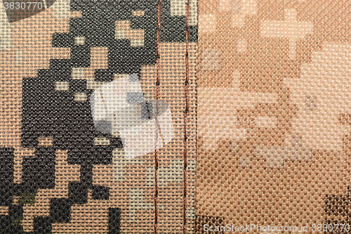 Image of close up of worn out olive green tone camouflage fabric