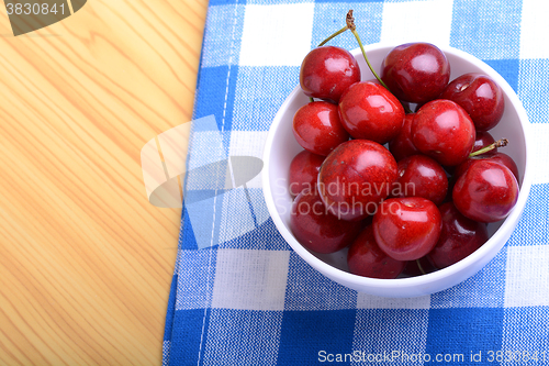 Image of Red ripe cherries in a white bowl