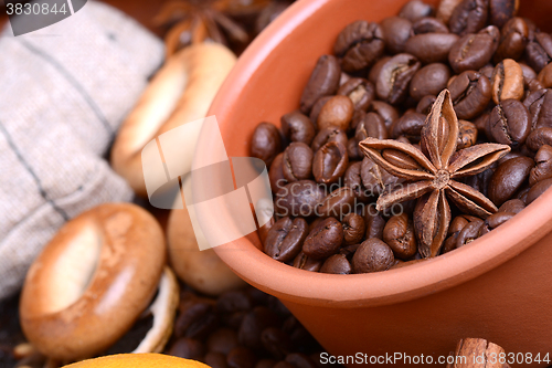 Image of orange and lemon, coffee beans and cinnamon on wooden brown background.