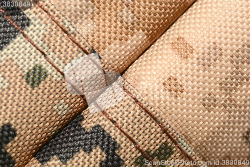 Image of close up of worn out olive green tone camouflage fabric