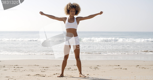 Image of Woman Practices Yoga On A Beach