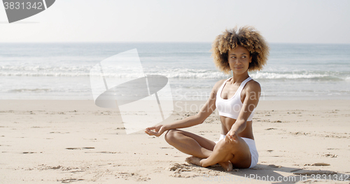 Image of Woman Meditating On Beach In Lotus Position