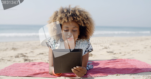 Image of Woman Uses A Tablet On The Beach