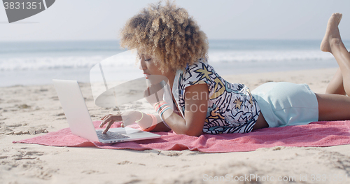 Image of Woman On The Beach Using A Computer