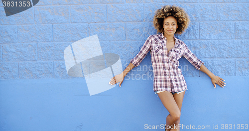 Image of Girl Standing At The Blue Brick Wall