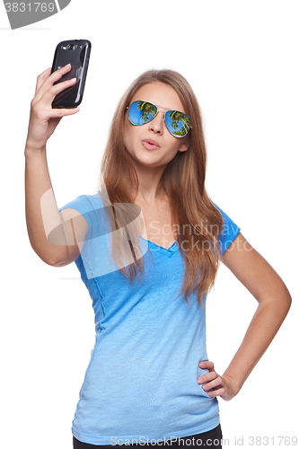Image of Woman in sunglasses with tropical resort reflection making selfie with smartphone