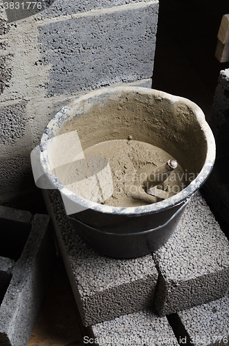 Image of A bucket with a solution and a trowel, close-up