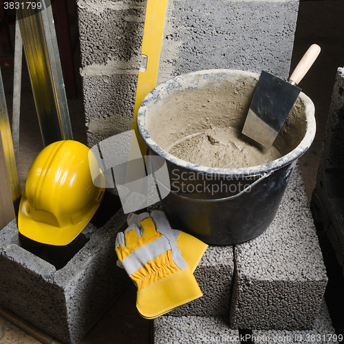 Image of Tools for bricklayer bucket with a solution and a trowel, close-