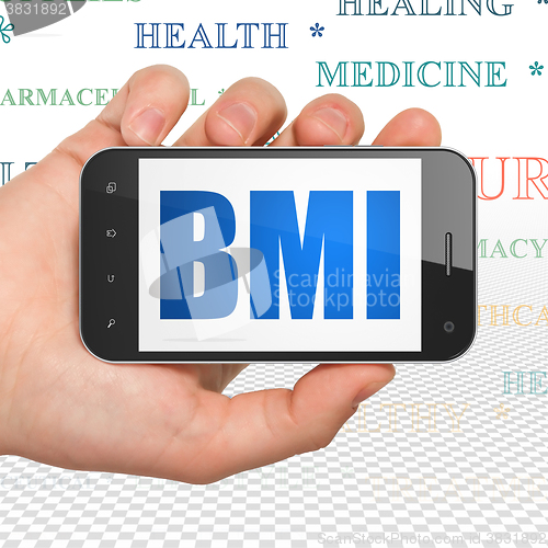 Image of Medicine concept: Hand Holding Smartphone with BMI on display