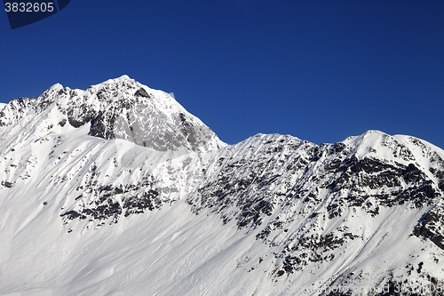 Image of Snowy mountains and blue clear sky at cold sun day