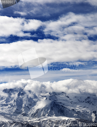 Image of Sunlight snowy mountains in clouds
