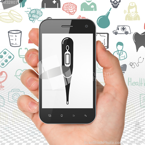Image of Health concept: Hand Holding Smartphone with Thermometer on display