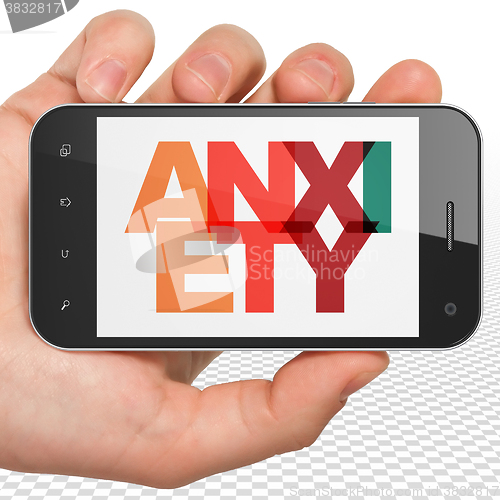 Image of Medicine concept: Hand Holding Smartphone with Anxiety on  display