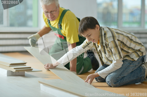 Image of man and grandson repairing in the room