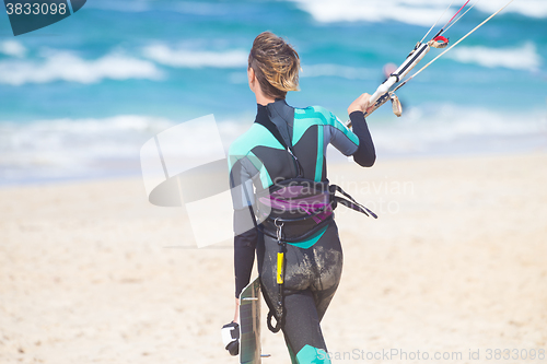 Image of Female kiteboarder with kiteboarding equipment.