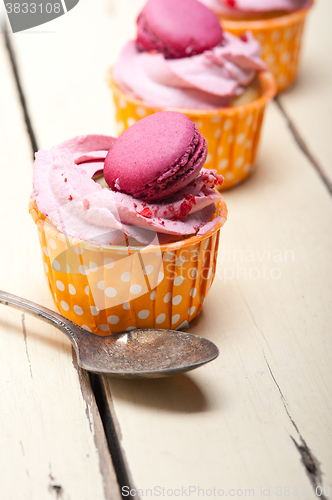 Image of pink berry cream cupcake with macaroon on top