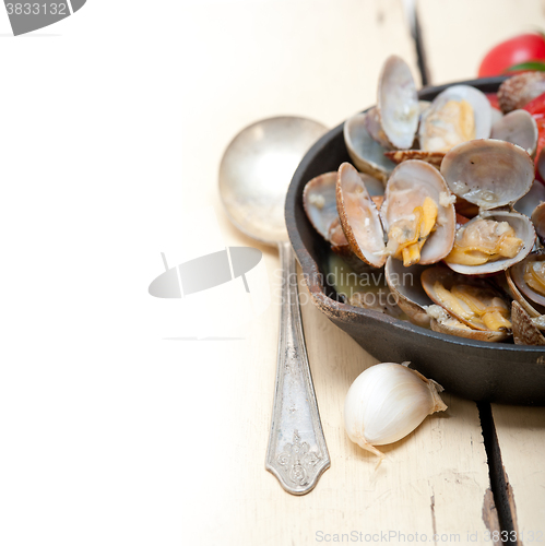 Image of fresh clams on an iron skillet