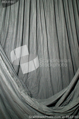 Image of Draped black background cloth lit with green gel