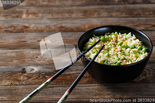 Image of bowl of noodles with vegetables on wood table