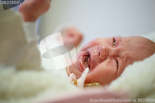 Image of Beautiful newborn baby crying in his bed