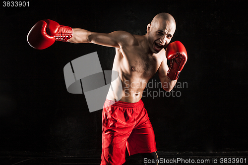 Image of The young man kickboxing on black