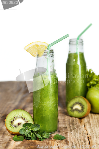 Image of The bottles with fresh vegetable juices on wooden table