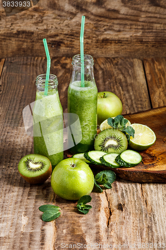 Image of The bottles with fresh vegetable juices on wooden table