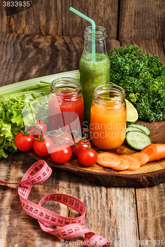 Image of The bottles with fresh vegetable juices on wooden table