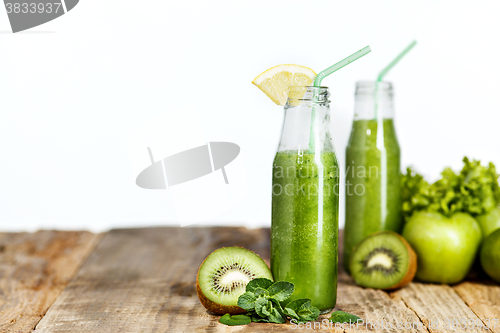 Image of The bottles with fresh vegetable juices on wooden table