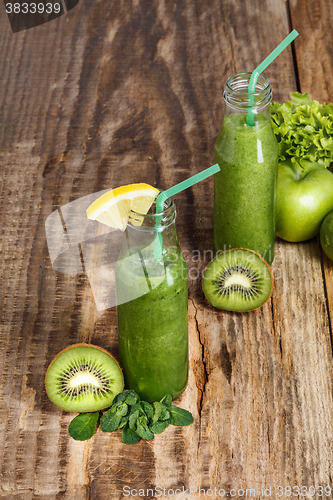 Image of The bottles with fresh vegetable juices on wooden table