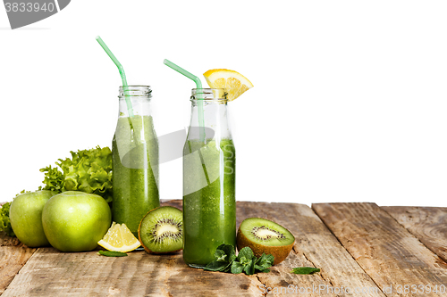 Image of The bottles with fresh vegetable juices on wooden table