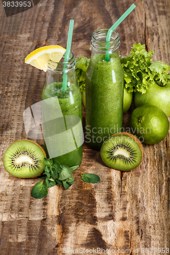 Image of The bottles with fresh vegetable juices on wooden table