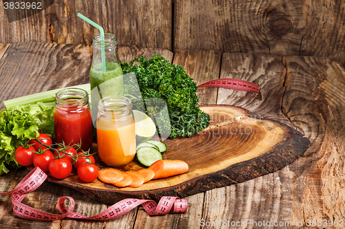 Image of The bottles with fresh vegetable juices on wooden table