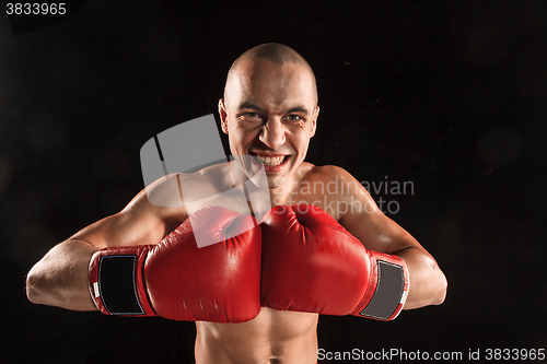 Image of The young man kickboxing on black  with screaming face