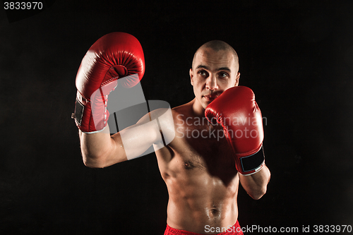 Image of The young man kickboxing on black