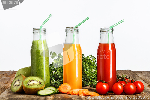 Image of The bottles with fresh vegetable juices on wooden table