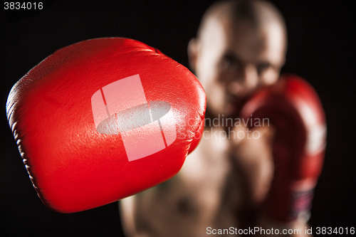 Image of The young man kickboxing on black