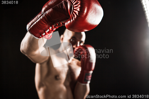 Image of The young man kickboxing on black