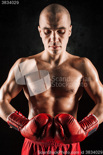 Image of The young man kickboxing on black