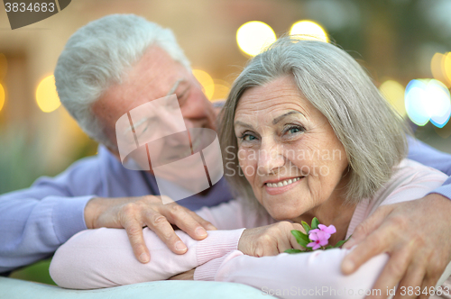 Image of smiling old couple with flower