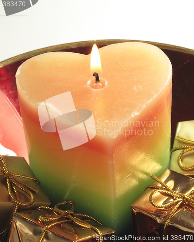 Image of heart candle and presents in a red glass bowl