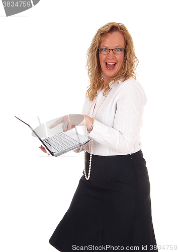 Image of Business woman laughing at laptop.