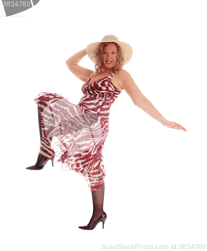 Image of Woman dancing in dress and hat.