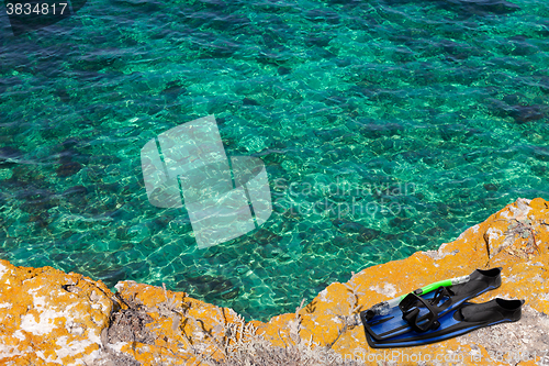 Image of Mask, snorkel and flippers on the cliff of sea