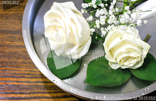 Image of Beautiful rose on the surface of the vessel with water.