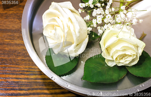 Image of Beautiful rose on the surface of the vessel with water.