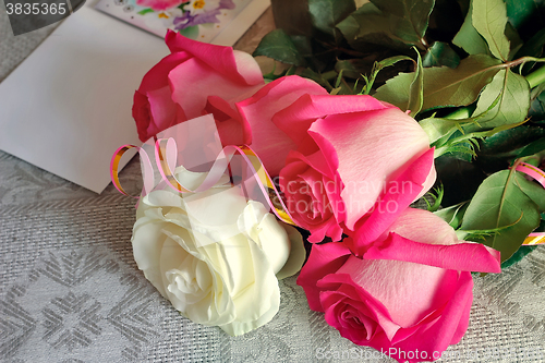 Image of A bouquet of roses and a letter of congratulation.