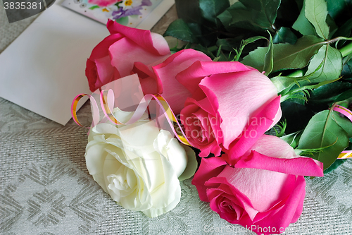 Image of A bouquet of roses and a letter of congratulation.